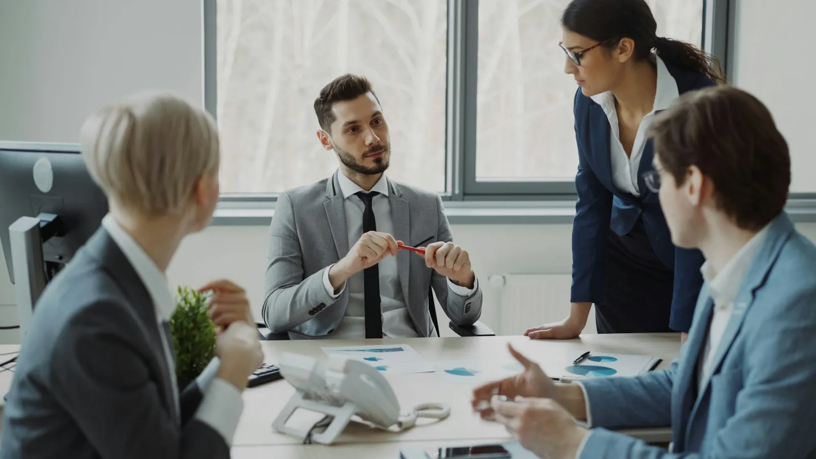 Business team meeting around a conference table in a bright office